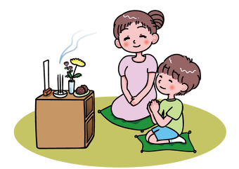 お供えをして先祖供養する親子